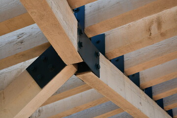 Large wooden beams connected with metal brackets.