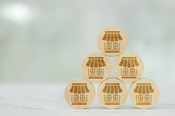 Wooden toy stack in pyramid with franchise business store for franchising to growth branch expansion and business banking loan or consumer resources service.