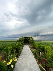 Roadside prayer shrine, Moldova with vibrant greenery and gray storm clouds rolling in (troita) 