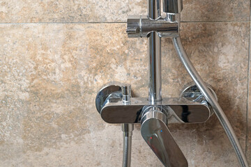 Clean faucet in shower stall on marble modern dark tile after cleaning. Cleanliness in the...