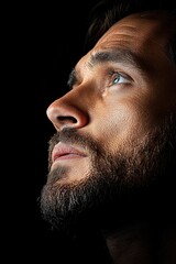 Obraz premium Close-Up Portrait of Thoughtful Bearded Man in Profile Against Dark Background