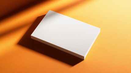 A pristine white blank business card, its edges subtly softened by the soft glow of daylight, lay flat on a vibrant orange surface, inviting the next message to take center stage.