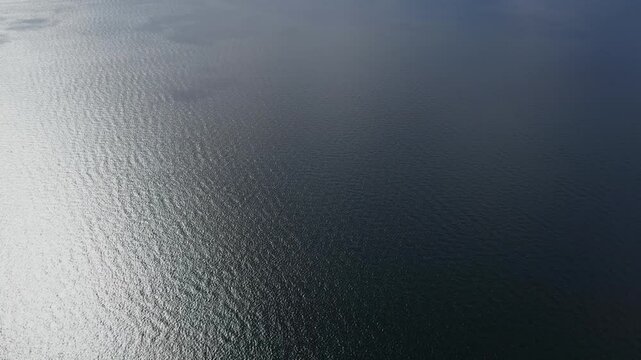 Calm Aerial View of Serene Water Surface Highlighted by Sunlight