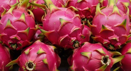 Vibrant pile of exotic dragon fruits displaying their unique pink scales