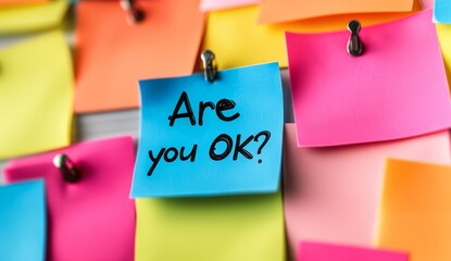 Colorful sticky notes on corkboard. One note says Okay Workplace mental health initiative. Employee support.