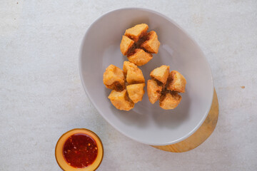 Fried Meatballs Arranged On A Gray Plate, Featuring A Crispy Golden Brown Exterior With Spicy Red Chili Sauce In A Small Bowl For Dipping.