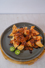 Golden Brown Fried Batagor Generously Coated With Rich Peanut Sauce, Sweet Soy, And Served With Fresh Calamansi Halves For A Savory And Treat.