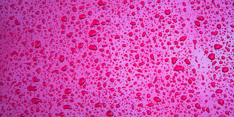 wide red purple background with the texture of rain drops on metal surface closeup