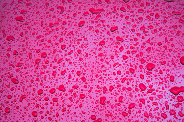 abstract red background with the texture of rain drops on a metal surface close-up