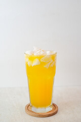 Fresh Orange Juice Served In A Tall Glass With Coconut Flesh On Top, Placed On A Wooden Coaster, Offering A Refreshing, Fruity, And Tropical Drink.