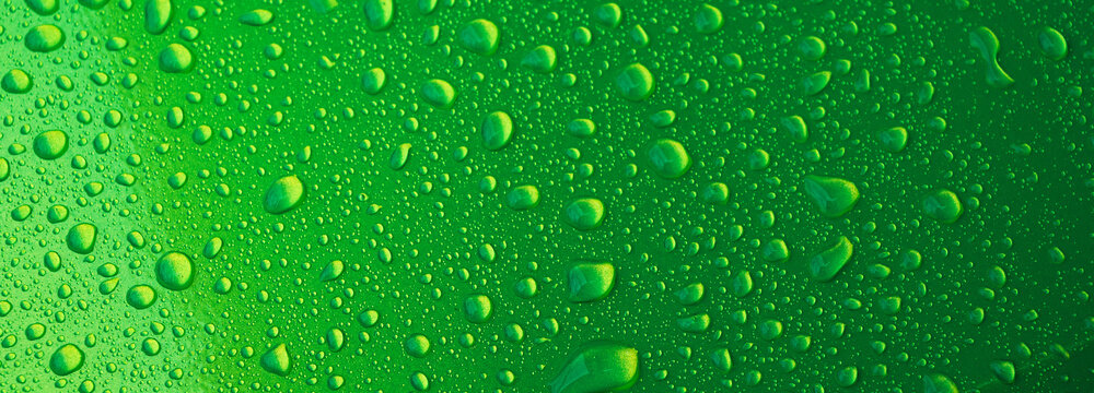 abstract green background with the texture of rain drops on a metal surface close-up