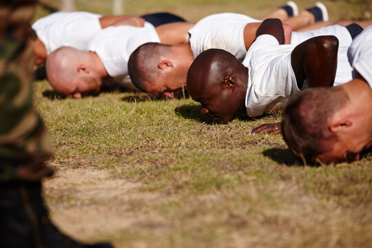 Military men, fitness and army with push ups for physical activity or training course on grass field. Male people, trainer or superior officer with team of soldiers in drill for bootcamp or workout