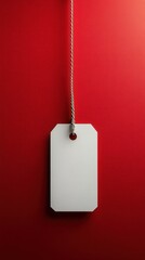 A minimalistic white tag hanging elegantly against a vibrant red wall creating a bold and eye-catching contrast