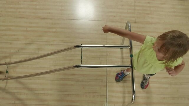 Little Girl Using a Bowling Ramp From Overhead