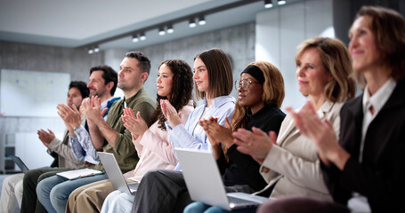 Thrilled crowd at business event watching diverse speakers presenting