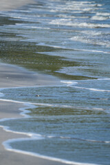 The sea water on the beach is a wave of various forms for background.