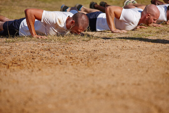 Men, outdoor and push ups in bootcamp for fitness, exercise or military challenge with mockup. Soldiers, space or people in physical activity for workout, training or strength assessment for survival