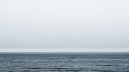Obraz premium The vast ocean meets the misty grey sky at the horizon
