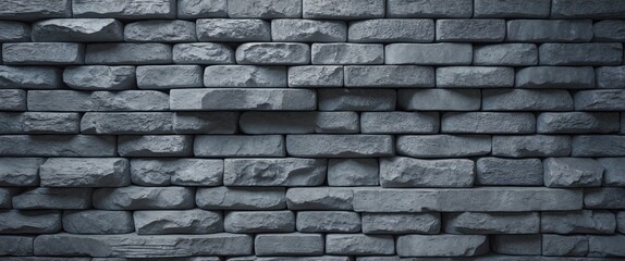 Obraz premium Gray textured brick wall background made of uneven stones arranged in a pattern for architectural or design use