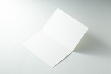 Blank White Card Resting on a Light Surface With an Open Fold Showcasing Its Empty Interior Space