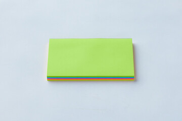 Bright Colored Sticky Notes Stacked Neatly on a Plain White Surface During Daylight