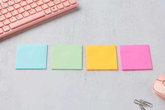 Colorful Sticky Notes Arranged on a Desk With a Pink Keyboard and Mouse During a Productive Workspace Session