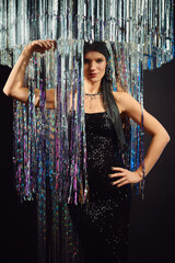 Stunning model poses elegantly under shimmering fringe decor at a glamorous event