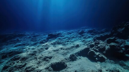 Fototapeta premium Deep Ocean Floor Dark Blue Underwater Scene with Rocky Seabed and Sunlight Beams
