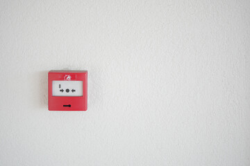 Fire alarm panel mounted on a white wall in a public building