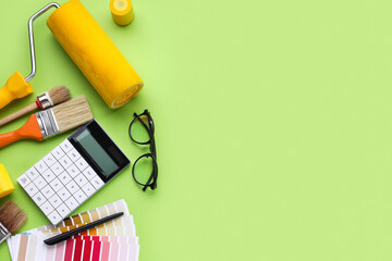 Composition with calculator and painting tools on green background. Renovation budget concept