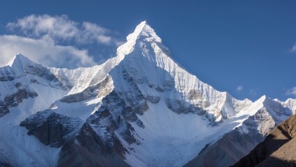 Snow-capped mountain peak against a blue sky with clouds natural landscape photography Copy Space