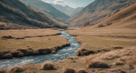 Mountain valley landscape with river flowing through grassy plains under cloudy sky in early spring scenery Copy Space