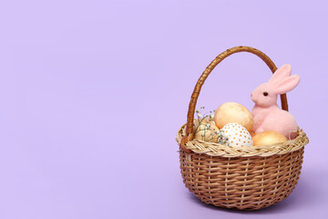 Basket with Easter eggs and bunny figurine on lilac background
