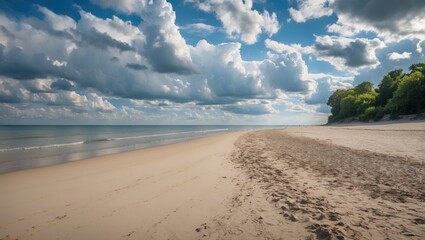 Coastal landscape with sandy beach, calm water and dramatic cloud formation under blue sky during daytime