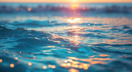 Close-up of gentle ocean waves reflecting sunlight during sunset with bokeh effect on surface water droplets