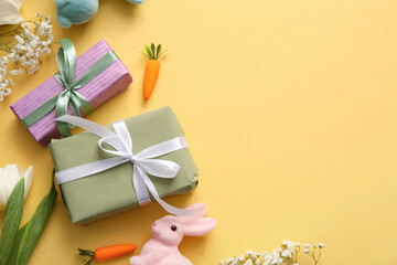 Easter bunny with gift boxes and flowers on orange background