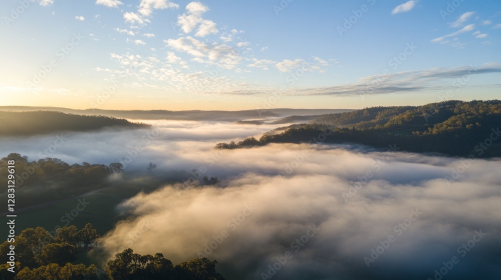 Poster soft clouds envelop rolling hills as dawn breaks, casting a warm golden glow over the tranquil lands