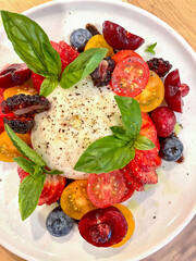 Burrata salad. Spring mix is topped with veggies, herbs and a drizzle of dressing.