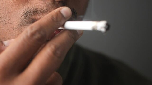 Close-up of man smoking cigarette in relaxed environment
