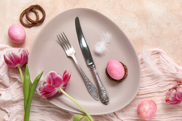 Table setting with Easter eggs, feathers and beautiful tulips on beige background