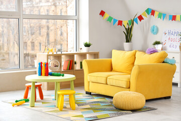 Interior of living room decorated for April Fools' Day with sofa and juggling clubs on table