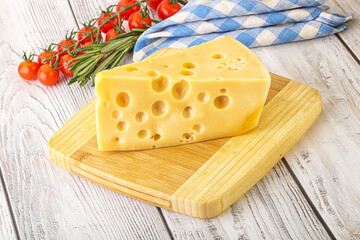 Maasdam cheese piece over board