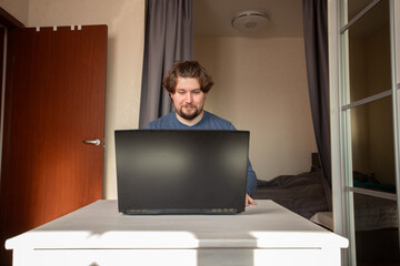 Happy man at laptop, casual remote worker expressing amazement and satisfaction, thrilled with...