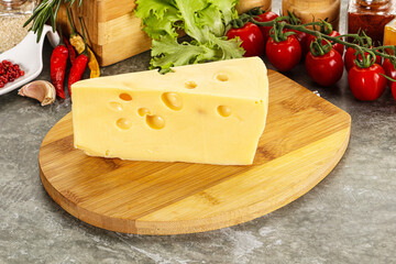 Swiss Maasdam cheese triangle over board