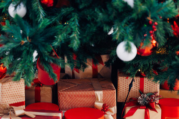 Beautiful christmas tree with gifts wrapped in festive paper and red ribbons