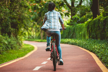 Naklejka premium Fitness woman cycling in the park