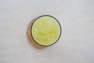 Top View Of Fresh Kedondong Juice In A Glass Filled With Ice Cubes On A Wooden Coaster, Showcasing...