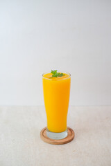 Mango Juice In A Tall Glass Garnished With Fresh Mint Leaves, Served On A Wooden Coaster Against A...
