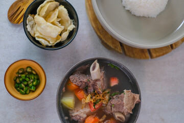 Flavorful Beef Rib Soup With Fresh Vegetables, Steamed White Rice, Crispy Crackers, And Sliced Green Chilies For A Perfect Comfort Food Experience.
