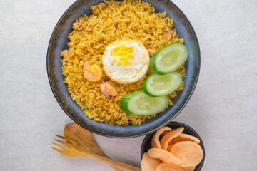 Kampung Fried Rice With Fried Egg, Shrimp, Fresh Cucumber Slices, And Crackers For A Flavorful And Hearty Indonesia Traditional Meal Experience.